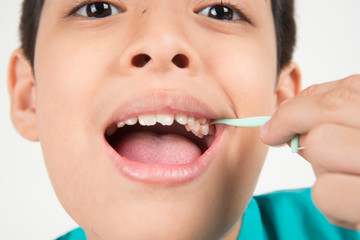 Little boy using dental floss to clean tooth