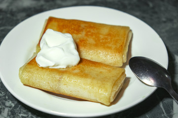 the pancakes with sour cream on a plate