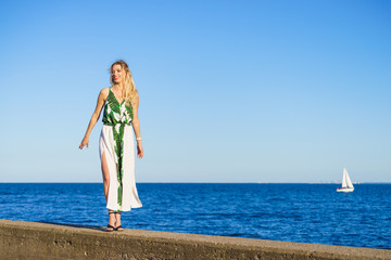 Woman in summer long dress against sea