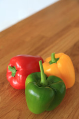 Composition with three color - red, green, yellow fresh sweet pepper or bell pepper on wooden background.