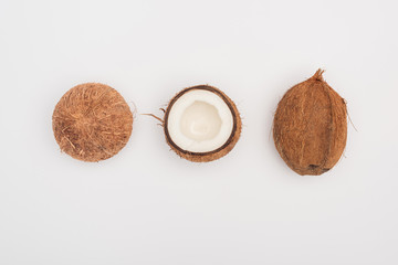 top view of whole coconut and coconut halves on grey background