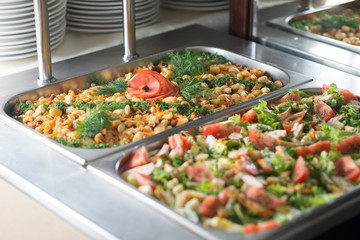 Fresh salads in boilers on the buffet table