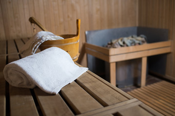 A towel and wooden bucket in the wooden sauna room
