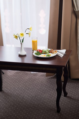 fresh breakfast with scrambled eggs and orange juice in the hotel room