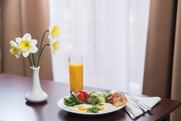 fresh breakfast with scrambled eggs and orange juice in the hotel room