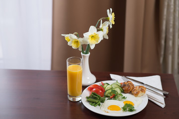 fresh breakfast with scrambled eggs and orange juice in the hotel room