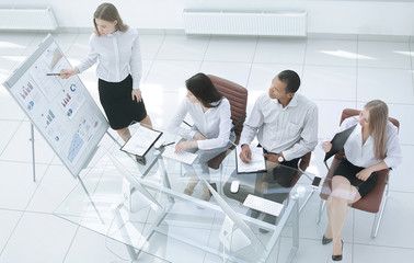 Young happy woman presenting her idea to colleagues at meeting