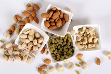 ssorted nuts on white, dry fruits, mix nuts, almond, cashew, pistachio, raisin
