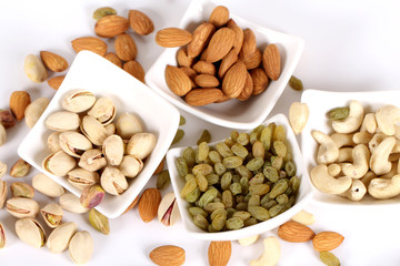 ssorted nuts on white, dry fruits, mix nuts, almond, cashew, pistachio, raisin