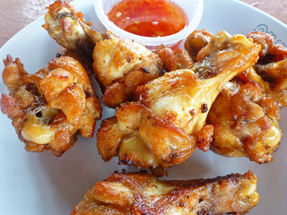 close up of fried chicken legs with chili sauce 
