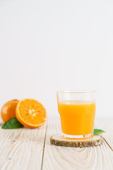 Obraz na płótnie Canvas Fresh orange juice on wood background