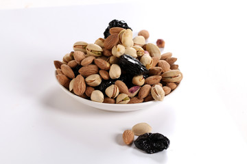 Assorted nuts on white, dry fruits, mix nuts, roasted almond, prunes, pistachio