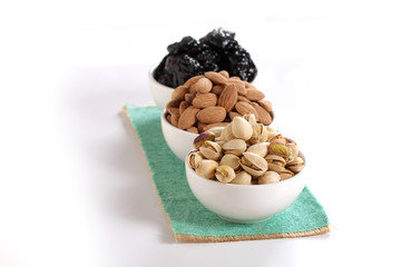 Assorted nuts on white, dry fruits, mix nuts, roasted almond, prunes, pistachio