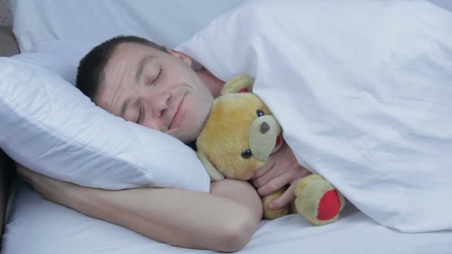 The happy man laying with soft toy