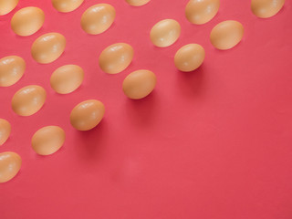 Brown eggs pattern on red background with copy space