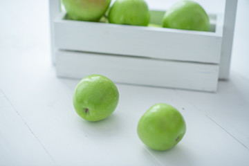 fresh green apples in a box on white background