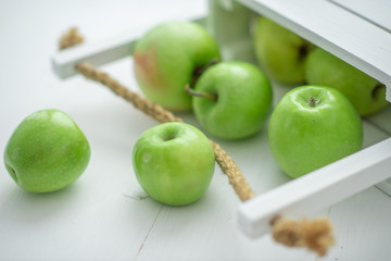 fresh green apples in a box on white background