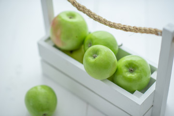 fresh green apples in a box on white background