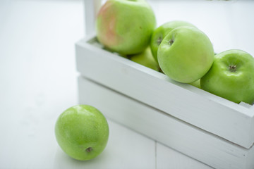 fresh green apples in a box on white background