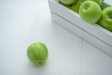 fresh green apples in a box on white background
