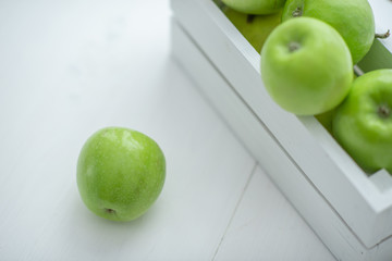 fresh green apples in a box on white background