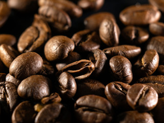 Focus on a single coffee bean on a background of many grains of coffee