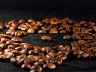 Focus on a single coffee bean on a background of many grains of coffee