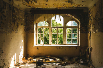 an old room with destroyed windows in an abandoned place