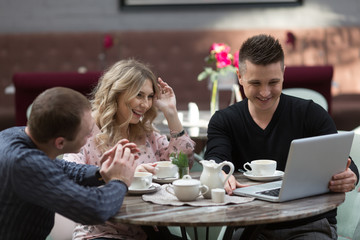 Three Businesspeople Working At Laptop In cafe