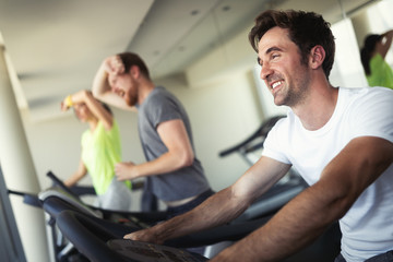 Fototapeta na wymiar Young people running on a treadmill in health club.