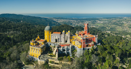 Fototapeta na wymiar Aerial view of Pena Palace, castle stands on Sintra Mountains; monument and one of the Seven Wonders of Portugal, mixture of eclectic styles includes the Neo-Gothic, Manueline, Islamic, Renaissance