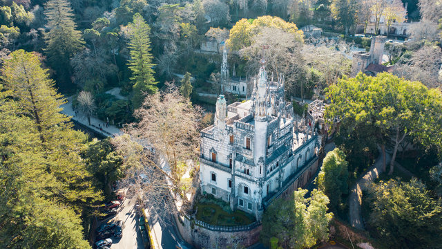 Aerial; drone view of Quinta da Regaleira palace on the Sintra hilltop; World Heritage Site by UNESCO; famous monument, touristic attraction of Portugal; sunny day in the national park