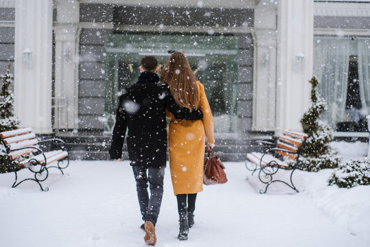 A couple enter the hotel in winter snowy day. Blurred image for background