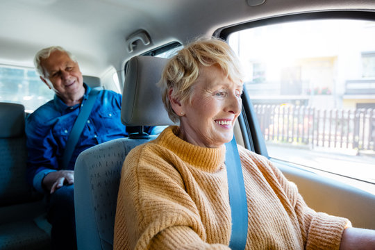 Senior Uber Driver Sitting In A Car With Male Passenger