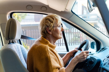 Senior woman driving a car carefully