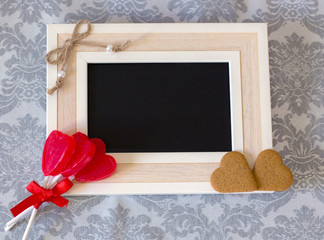 heart shaped lollipops and cookies and wooden blackboard with space to write