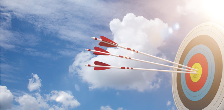 Zielscheibe mit 3 Pfeilen vor einem blauen Himmel