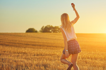 Cute young woman jumping in a wheat field.