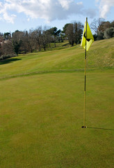 Obraz premium Golf course with hole and flag on a sunny day