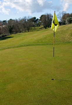Golf course with hole and flag on a sunny day