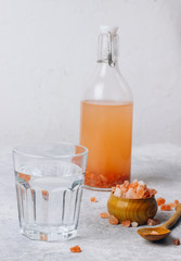 water in a glass and Himalayan salt isolated on white background