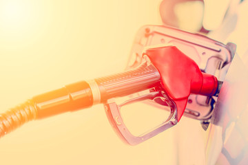 Filling a car with fuel. Petrol pumping gasoline at gas station. Close up toned image