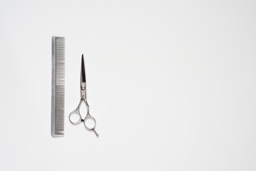 flat lay hairdressing scissors and a comb isolated on white background