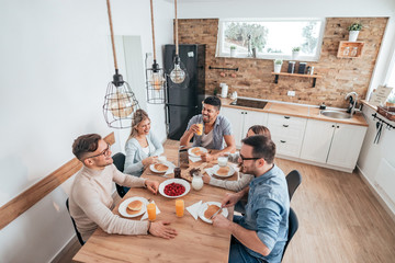 High angle image of five multi-ethnic friends or roommates eating homemade pancakes.