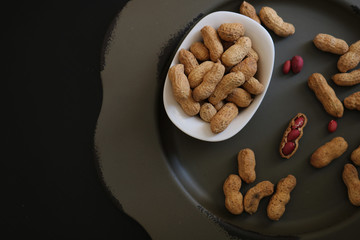 Peanuts in shell on a black background.