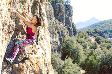 Obraz premium Woman climbing in Greece and beautiful forest and cliff landscape on the background