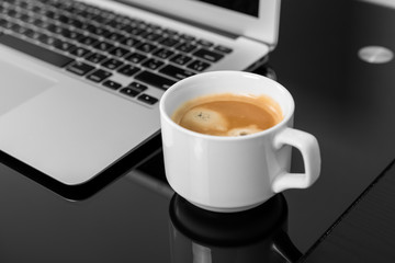 Close up of hands typing on a laptop in a coffee shop