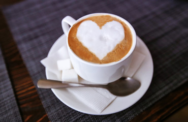 Cappuccino with heart in a white cup. Fresh morning aromatic breakfast.
