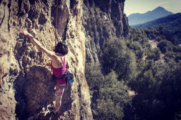 Obraz premium Woman climbing in Greece and beautiful forest and cliff landscape on the background