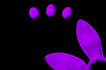 Bunny ears and eggs on a black background.
